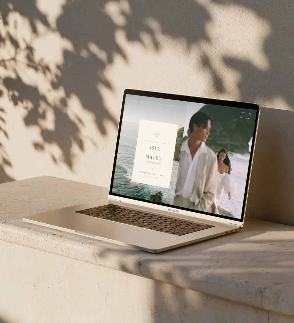 Bali wedding website shown on a laptop on a sunlit stone ledge