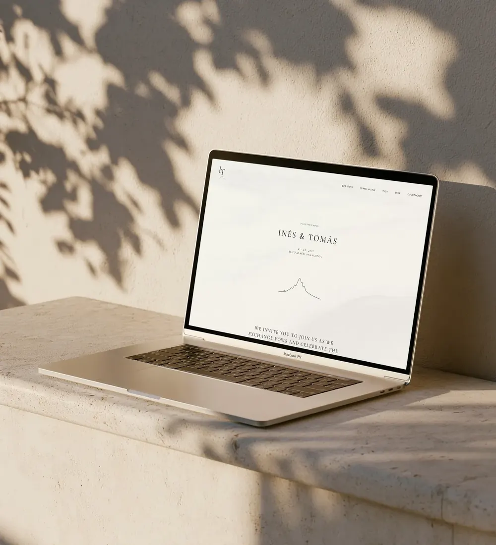 Glacier wedding website shown on a laptop on a sunlit stone ledge