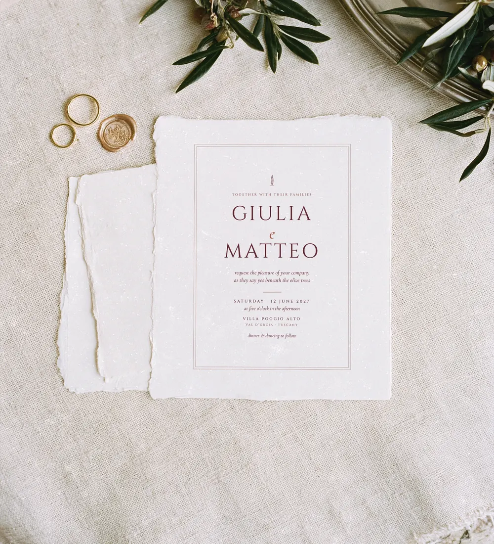 Toscana wedding invitation in wine red on handmade paper with olive branches, gold rings and a wax seal on linen