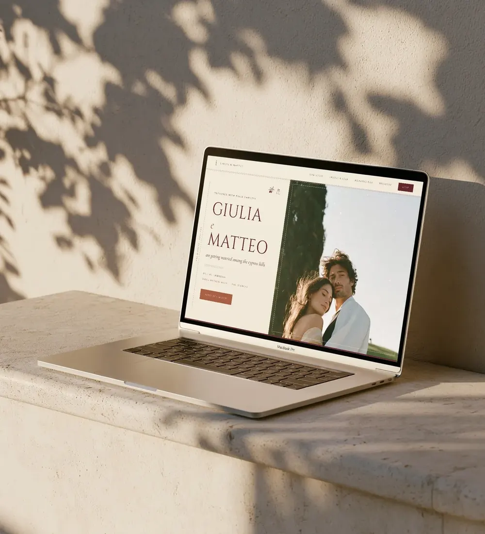 Toscana wedding website shown on a laptop on a sunlit stone ledge