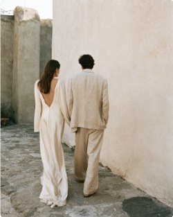 Bride and groom walking through a narrow stone alley