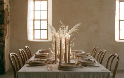 Long reception table with pampas grass and candles in a plaster room