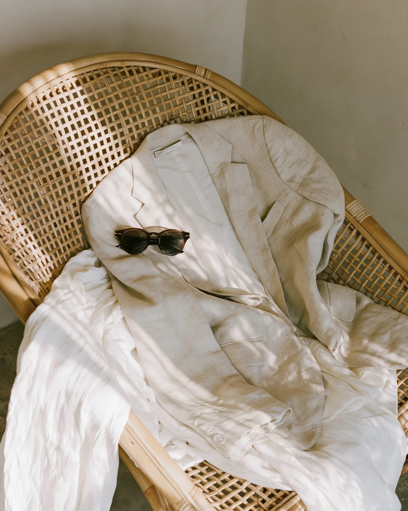Rattan chair with linen and sunglasses
