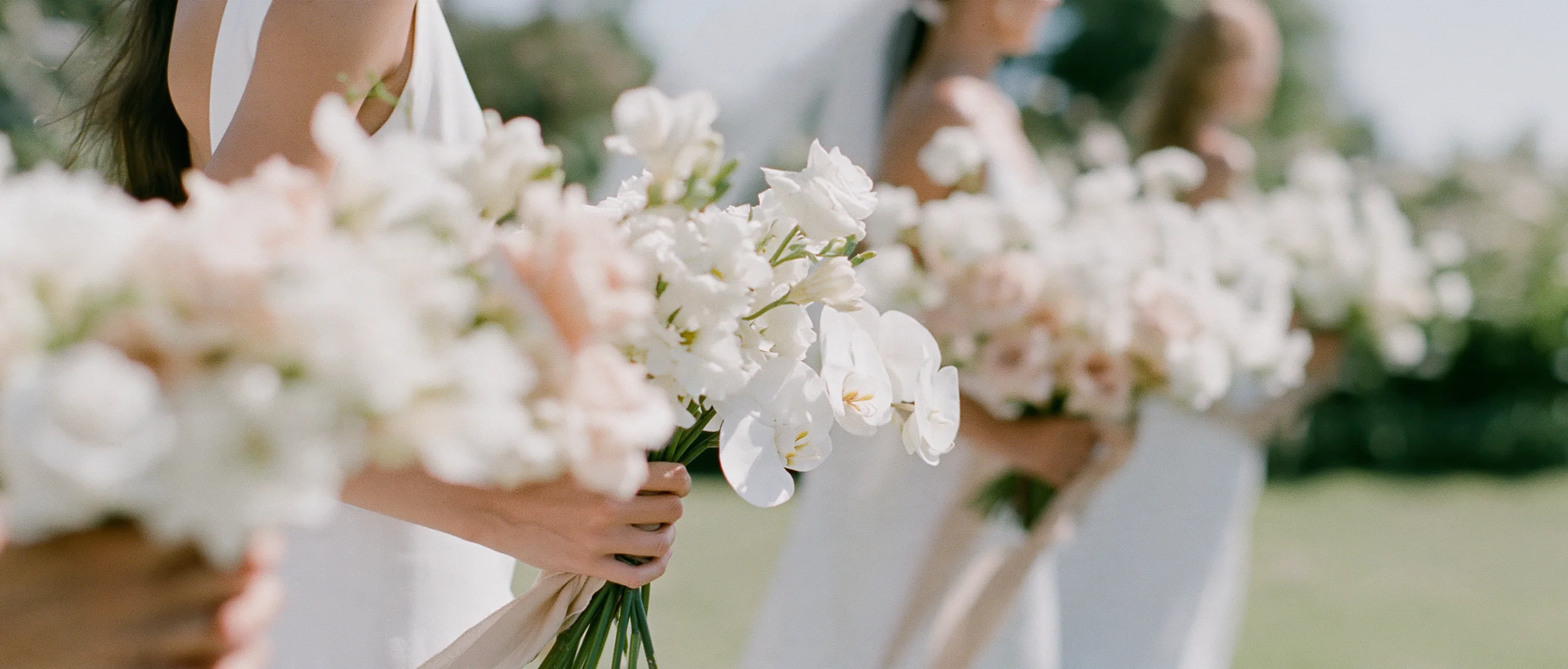 Bridesmaids holding white bouquets