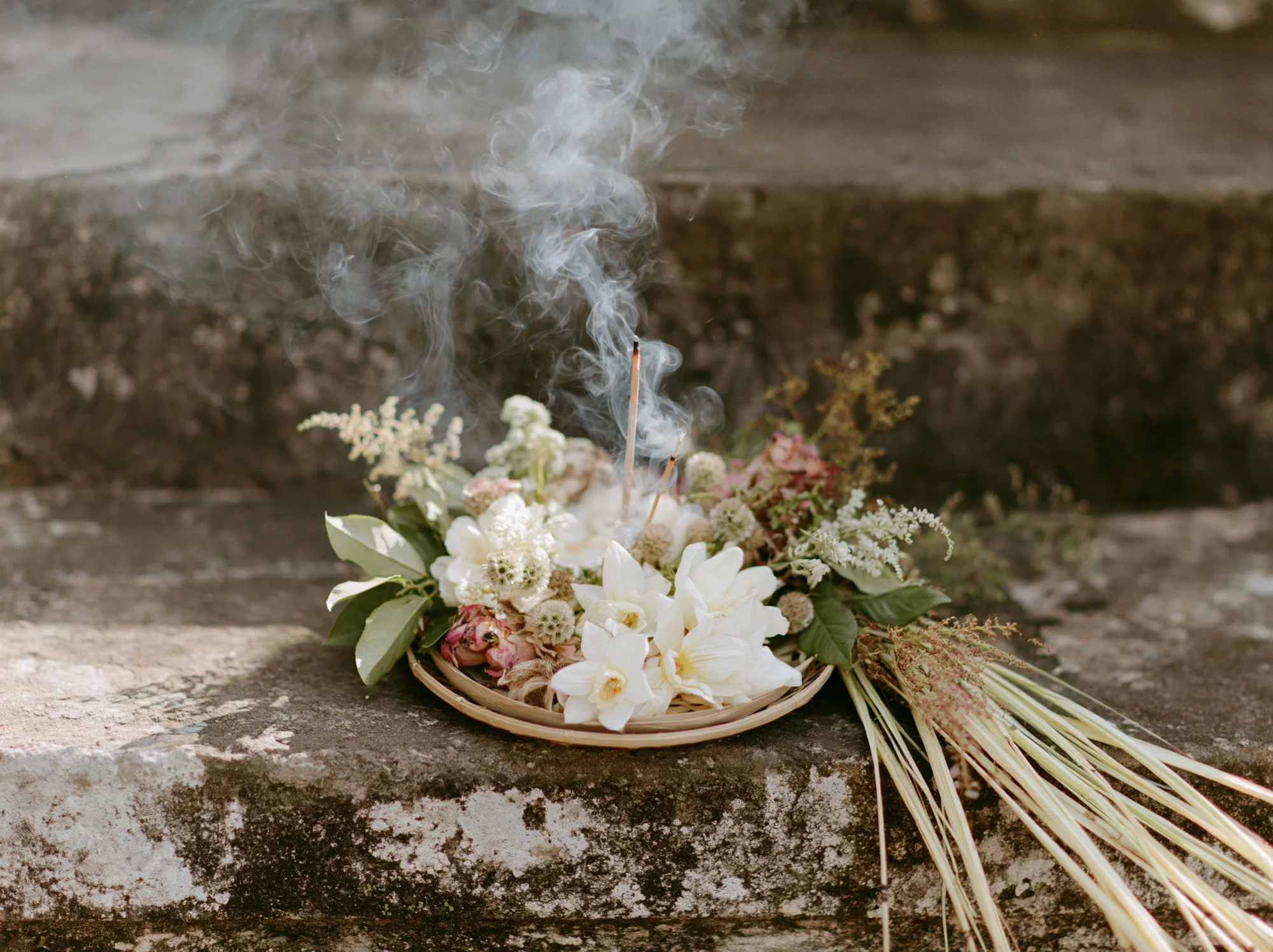 Balinese canang sari offering with incense smoke