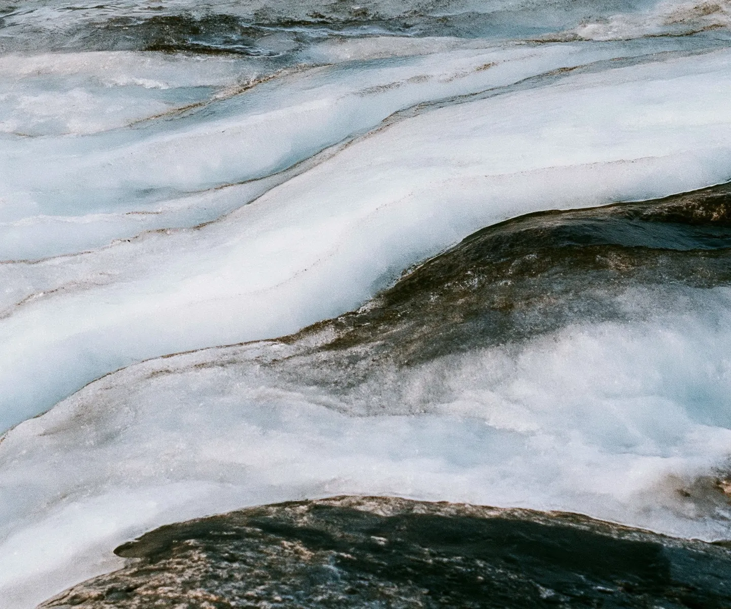 Close-up of glacier-blue rushing water and white foam