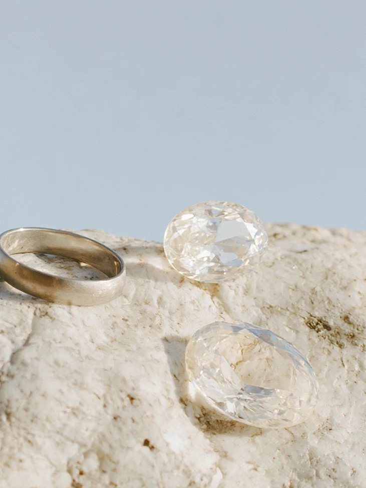 Two gold wedding rings resting on a pale rock