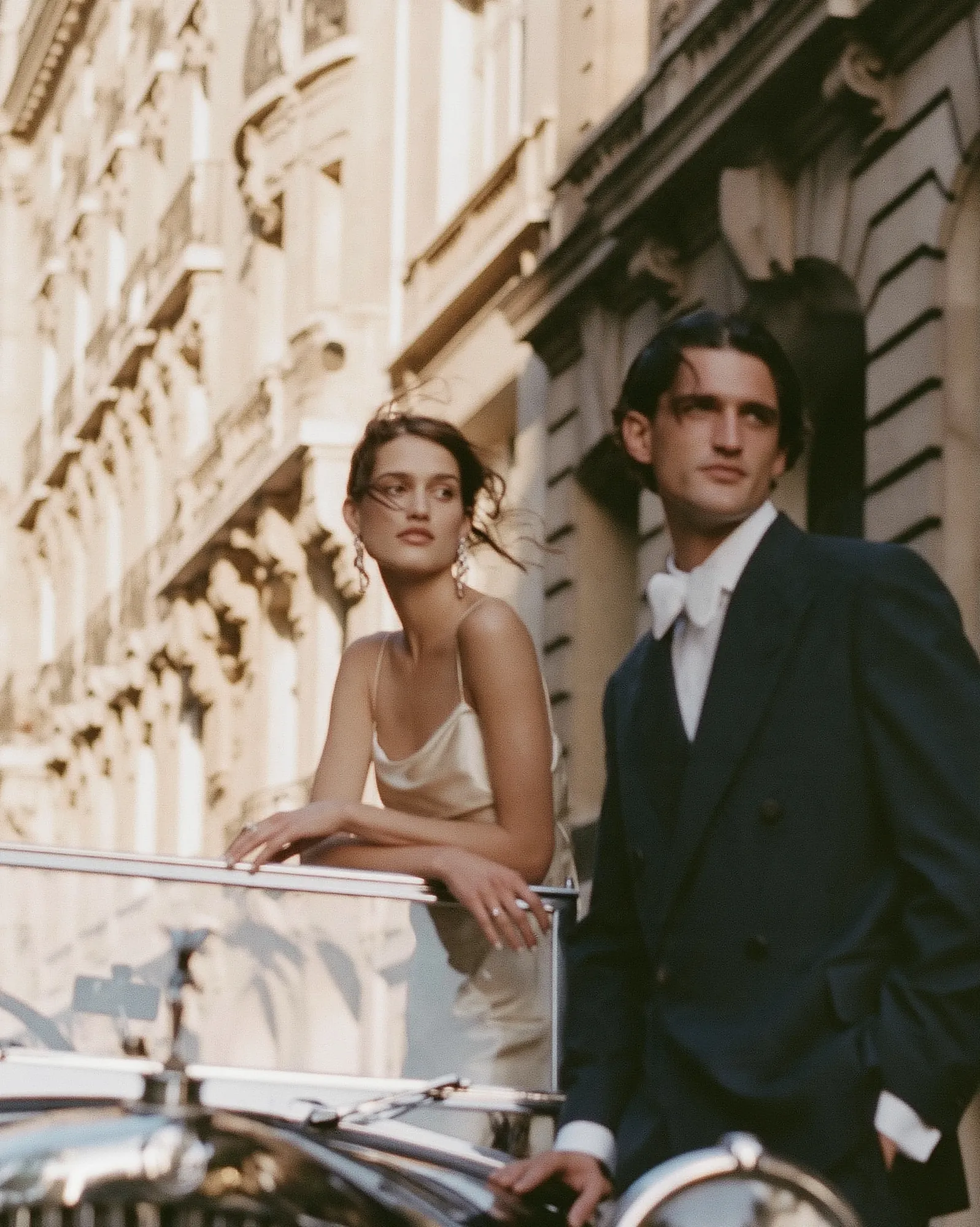 Elegant couple in a vintage car on a Parisian street