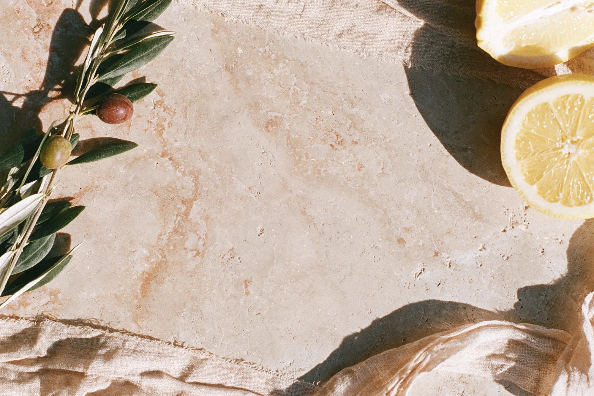 Fresh lemons and linen on a travertine stone surface